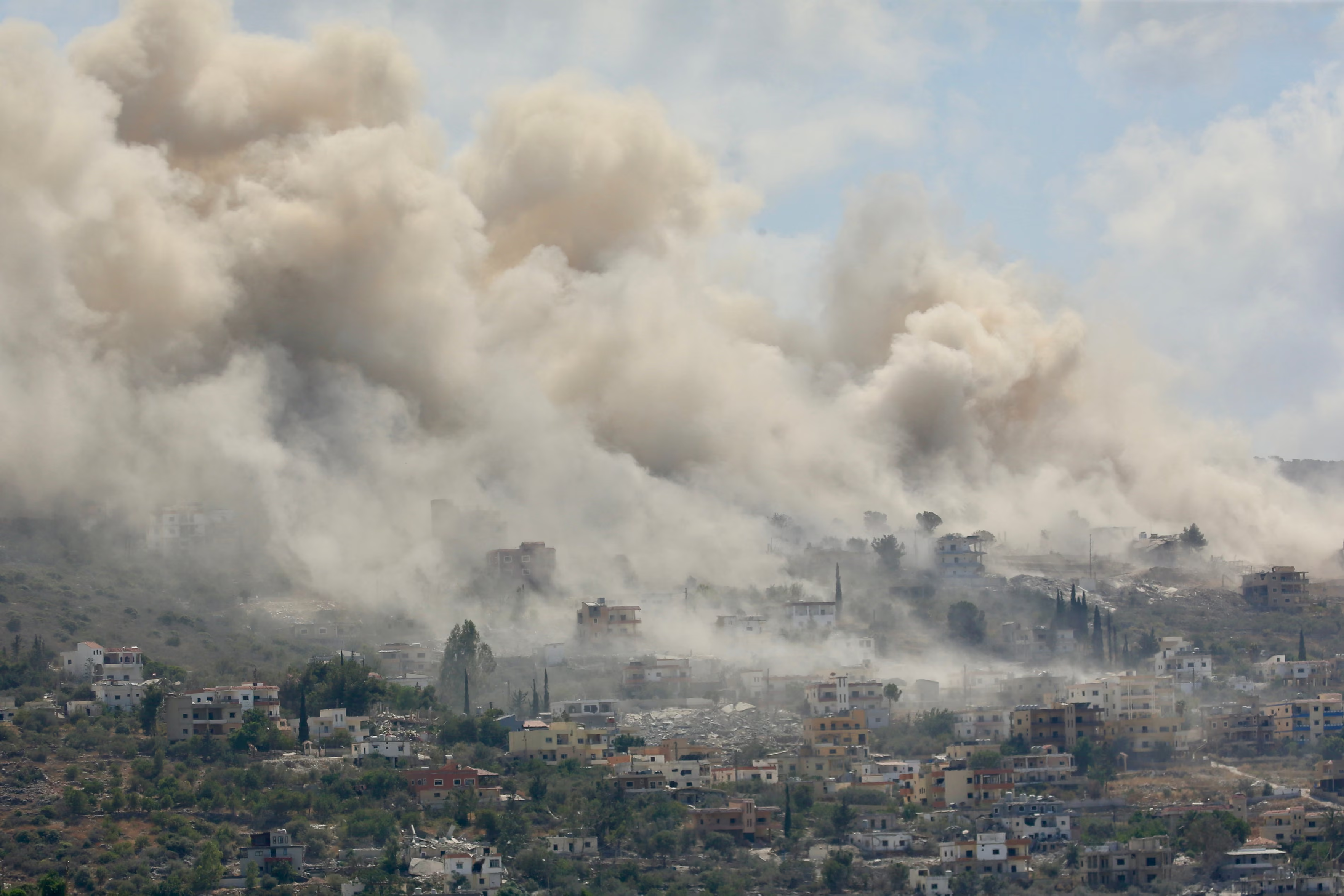 Smoke billows from houses hit during Israeli attacks in the town of al-Mansouri in southern Lebanon.