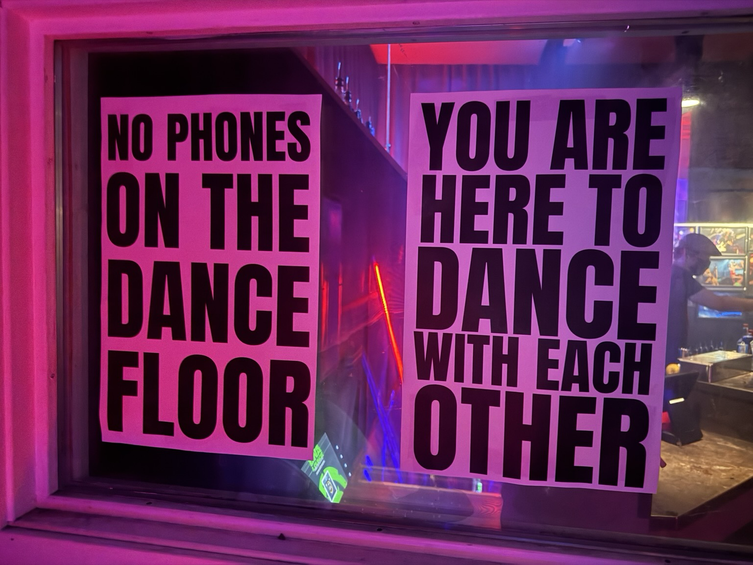 Two signs at DNA Lounge that together read: No phones on the dance floor / you are here to dance with each other.