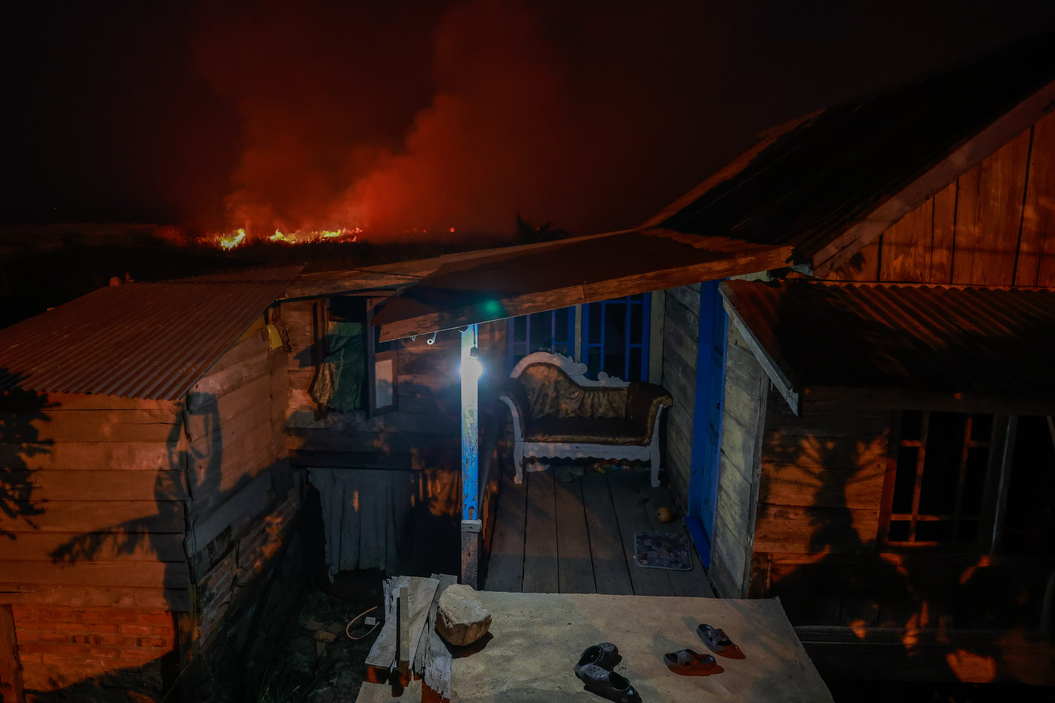 A house stands empty as a wildfire approaches.