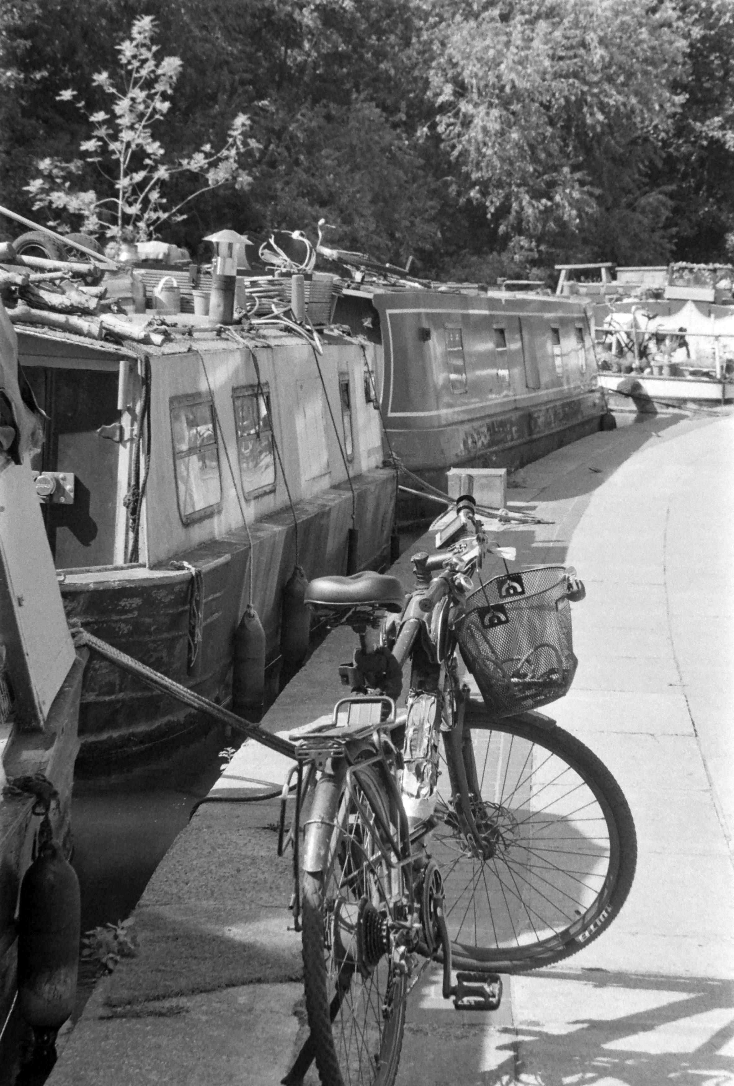 un vélo garé sur le quai devant une péniche