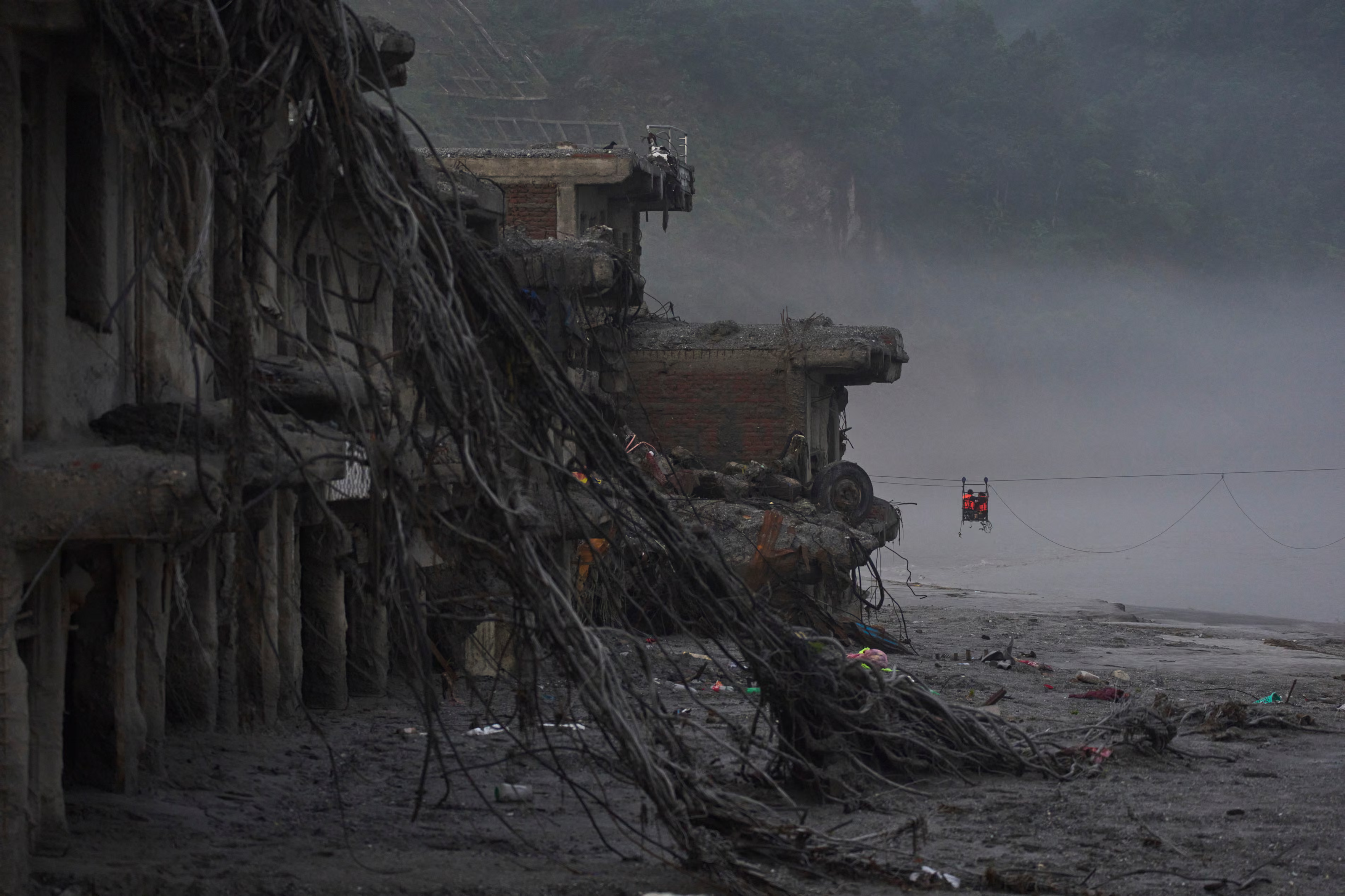 Residents commute across the Trishuli River on a zip wire.