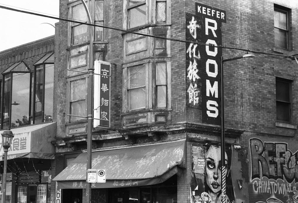 A Chinatown hotel. Graffiti face. Burnt out restaurant below.