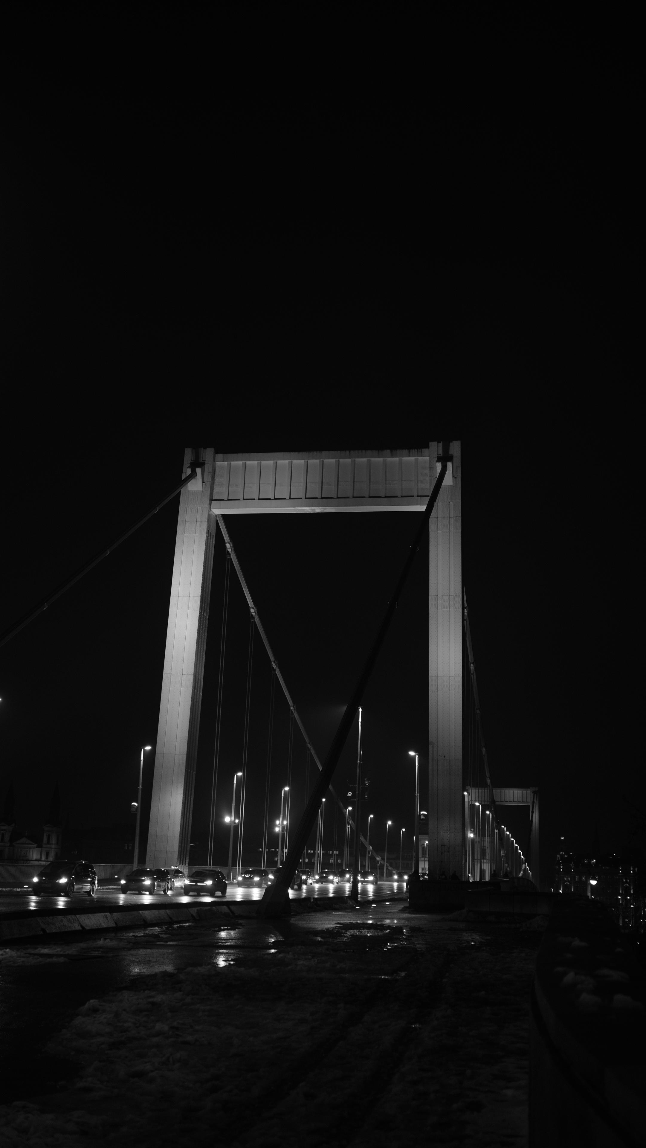 A night photo of a bridge. Photo taken in black and white