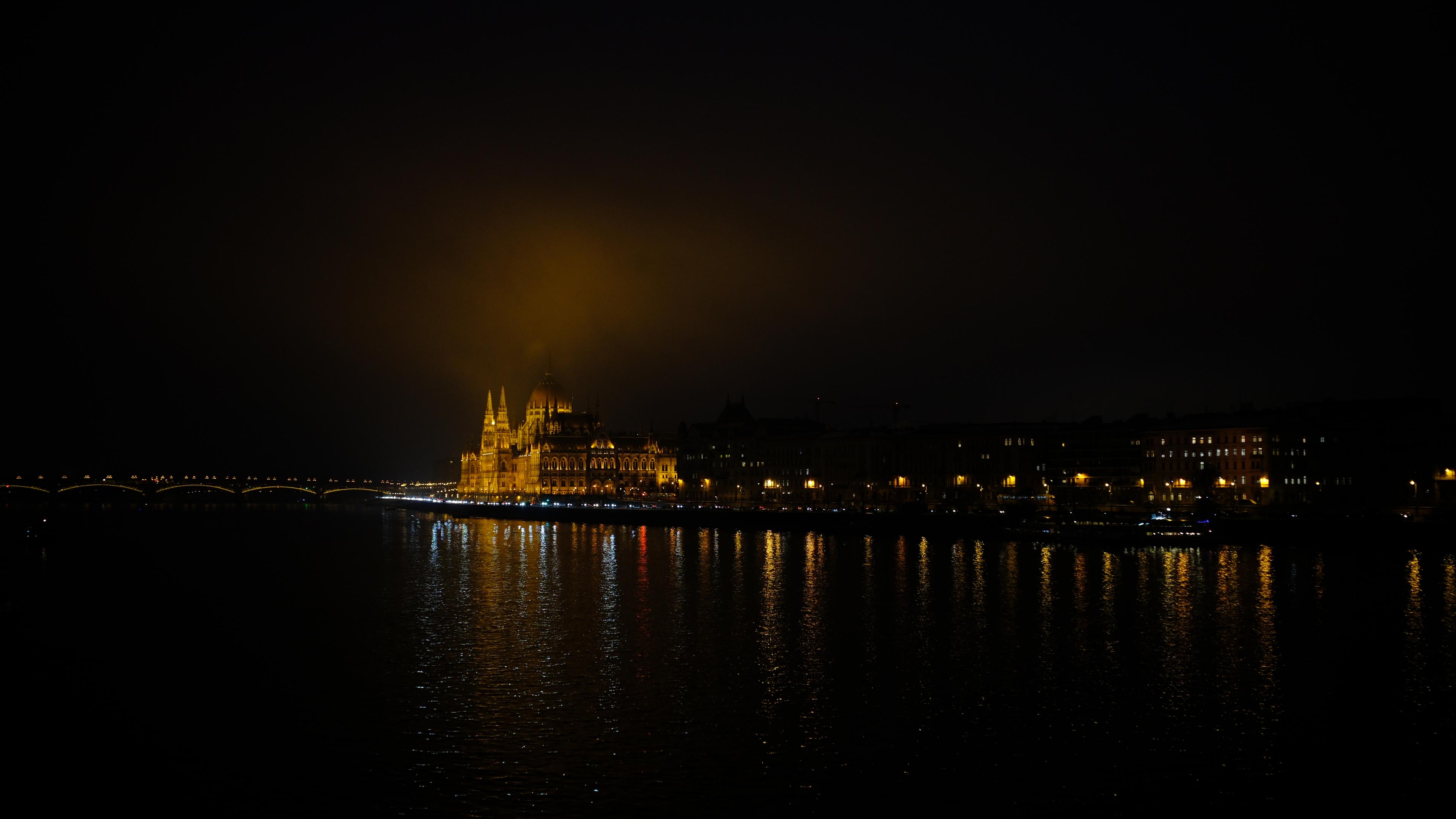 A picture of the Hungarian Parliament building at night from a side angle.