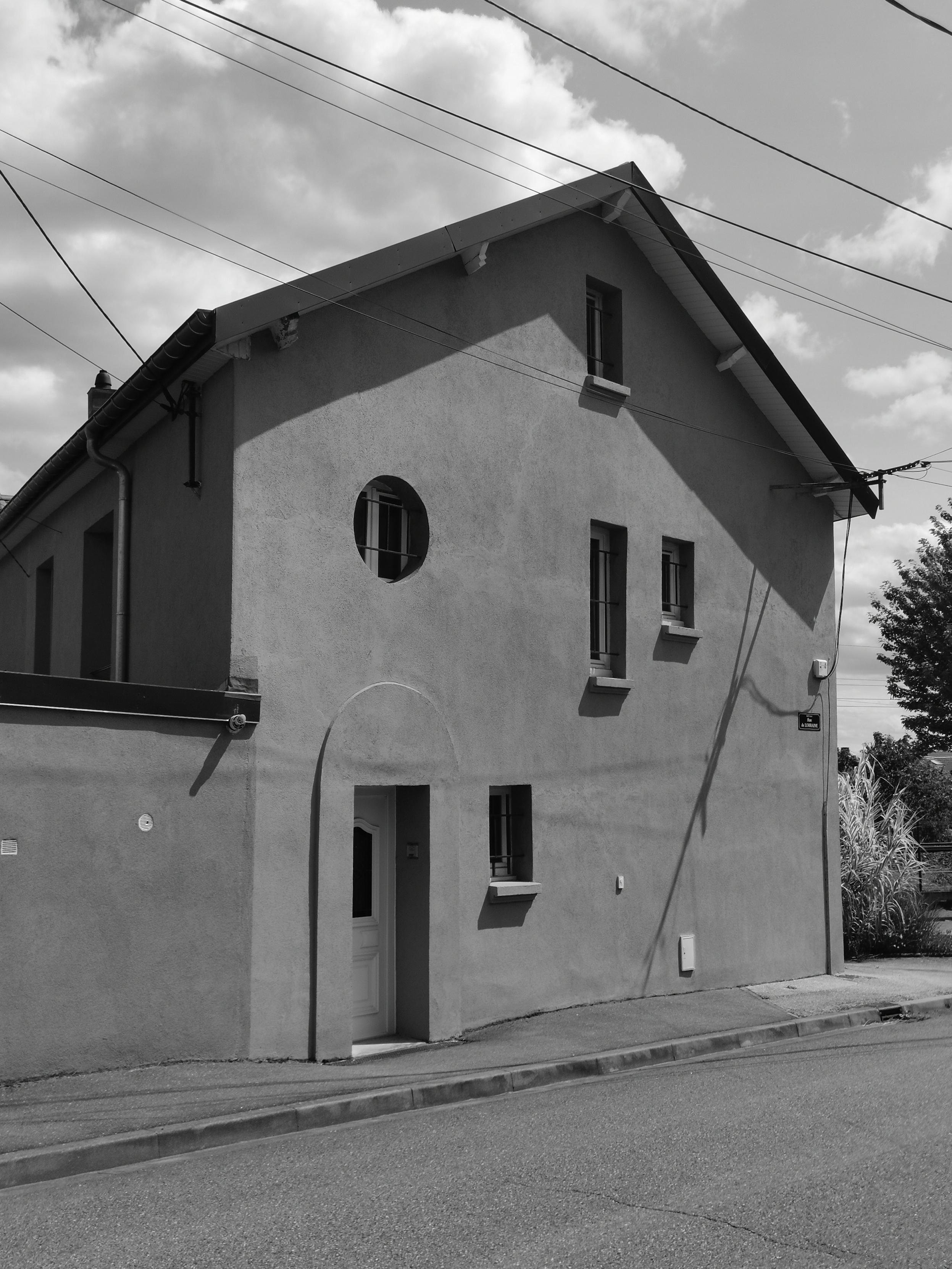 Façade d'une maison individuelle au ouvertures irrégulières