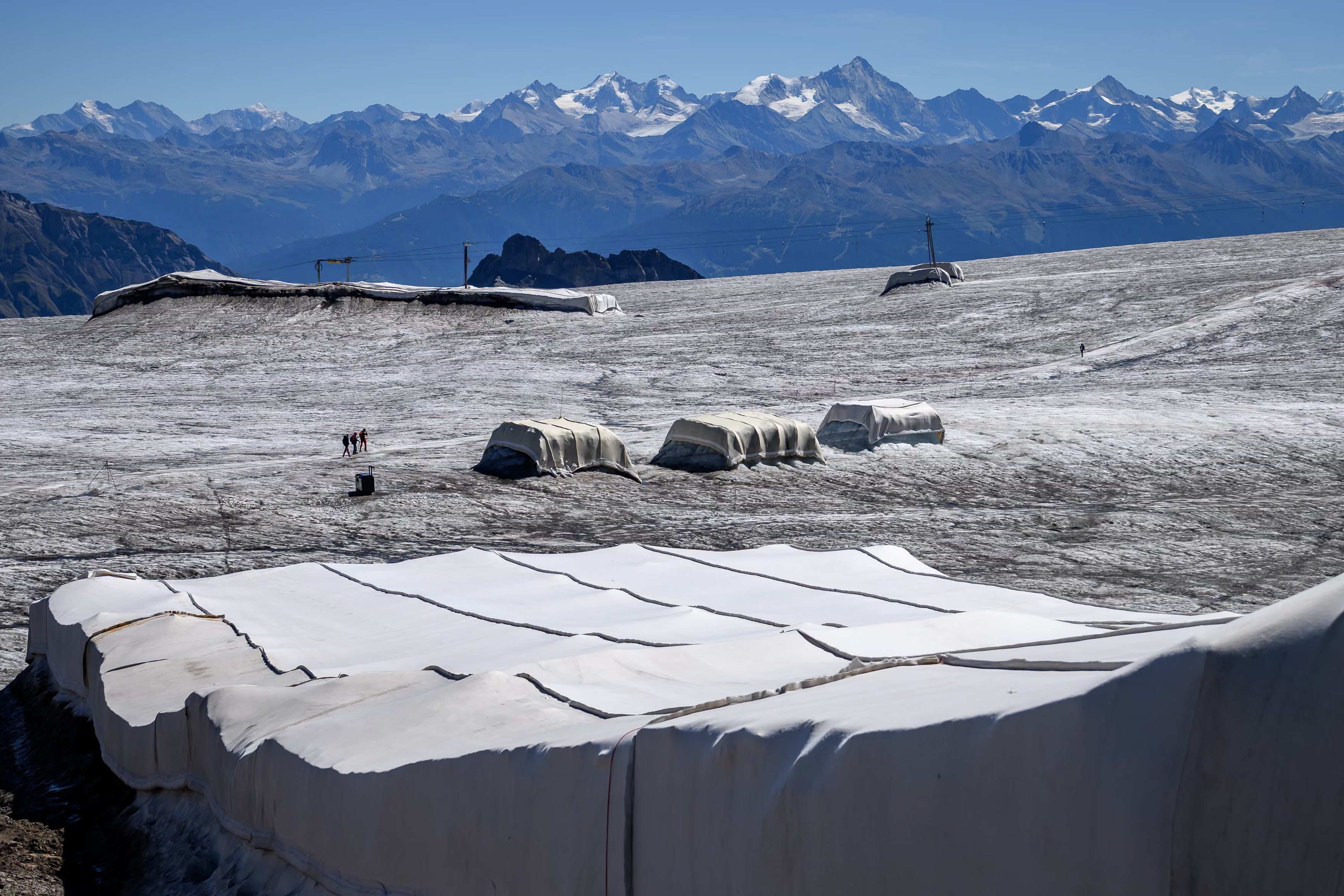 Blankets made of sheep’s wool and synthetic material are laid over glacier ice.