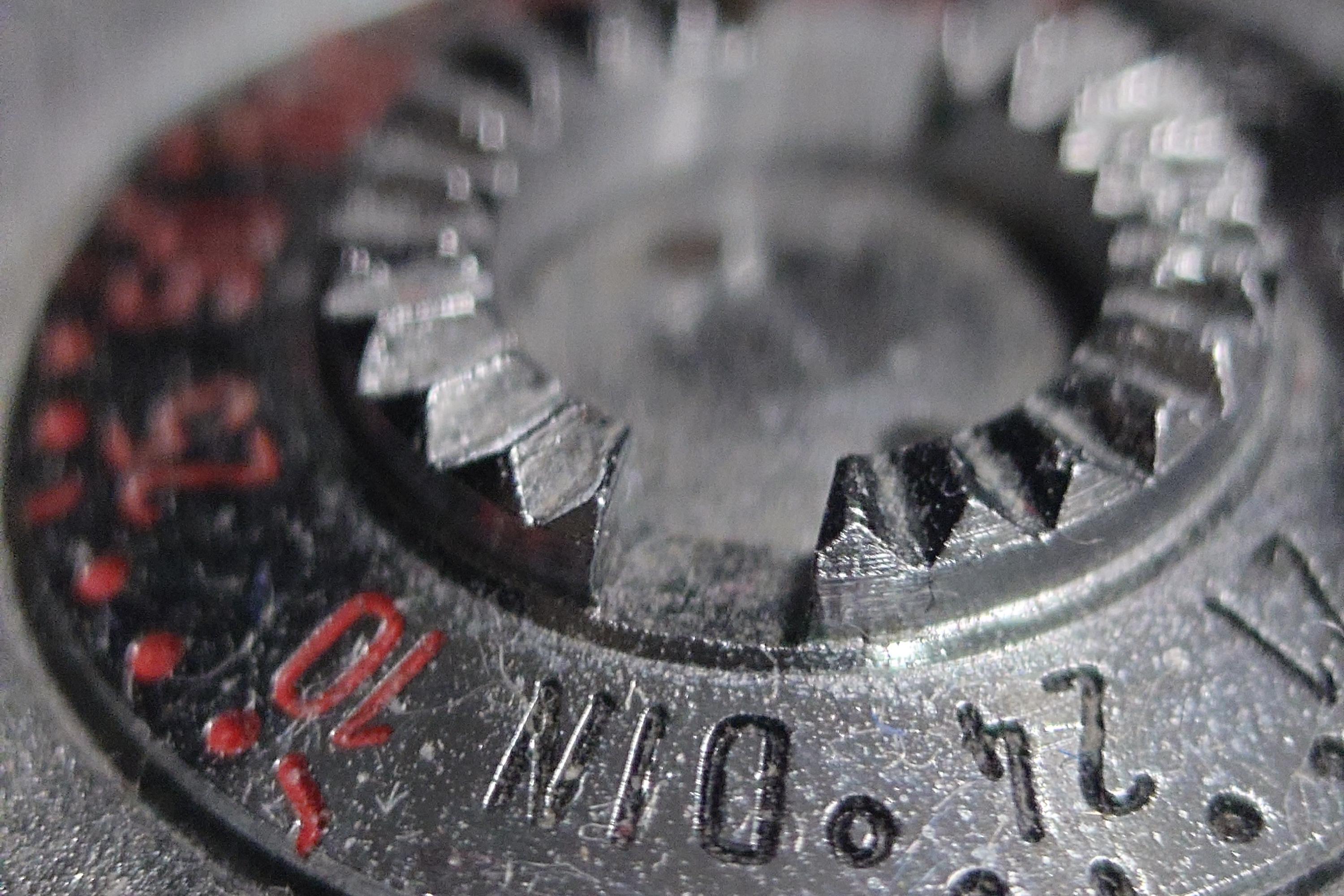 Zbliżenie makro na metalowe, zębate pokrętło nastawy czułości błony fotograficznej (oznaczenia DIN oraz ASA). Fotografia ukazuje detale konstrukcyjne oraz patynę czasu na mechanicznym korpusie vintage aparatu. Przykład dawnej precyzji wykonania, gdzie każdy element mechaniczny musiał działać bez udziału elektroniki. Jest to jeden z retro aparatów ze Studio Stawki.