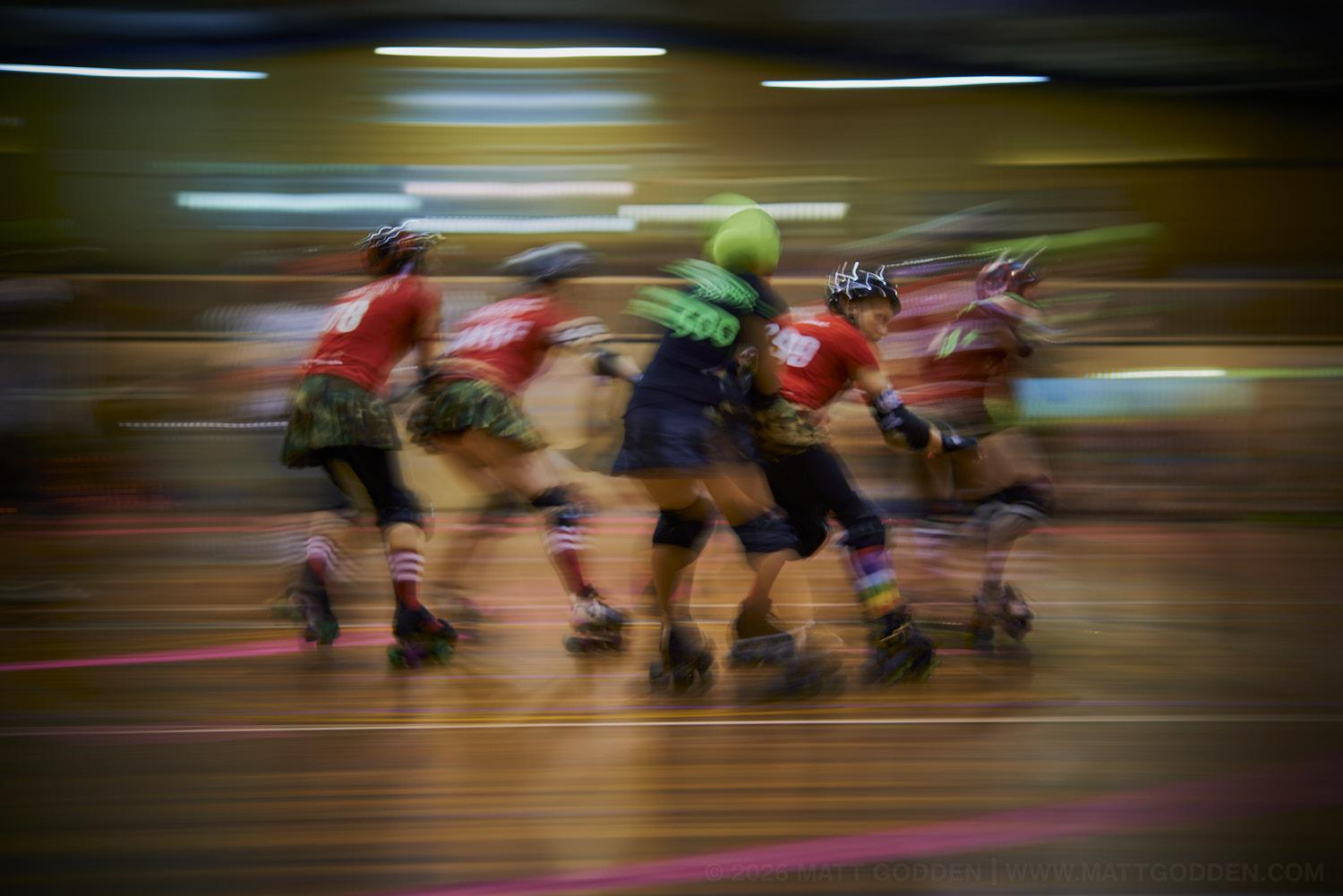 A long exposure image of roller derby competitors from the D'Viants (lime green), and the Screaming Assault Sirens (red). 2013/11/09