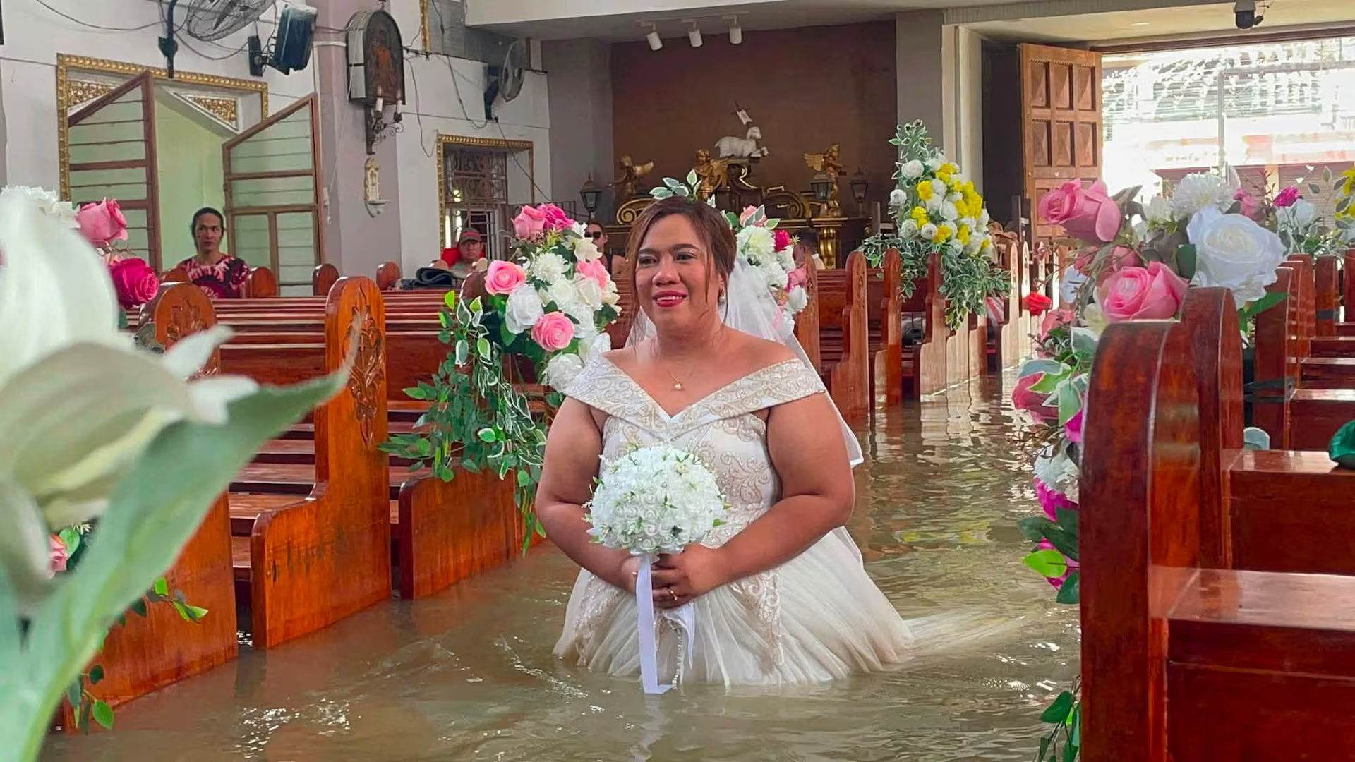 A Filipino bride walks the aisle of St. John the Baptist Parish in floodwaters at Hagonoy, Bulacan province, Philippines