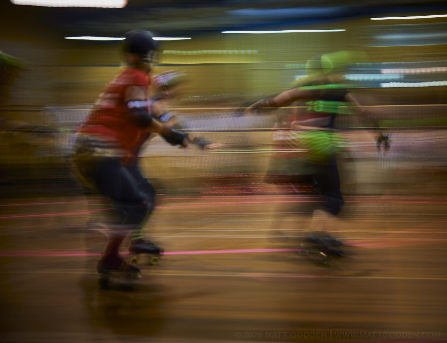 A long exposure image of roller derby competitors from the D'Viants (lime green), and the Screaming Assault Sirens (red). 2013/11/09