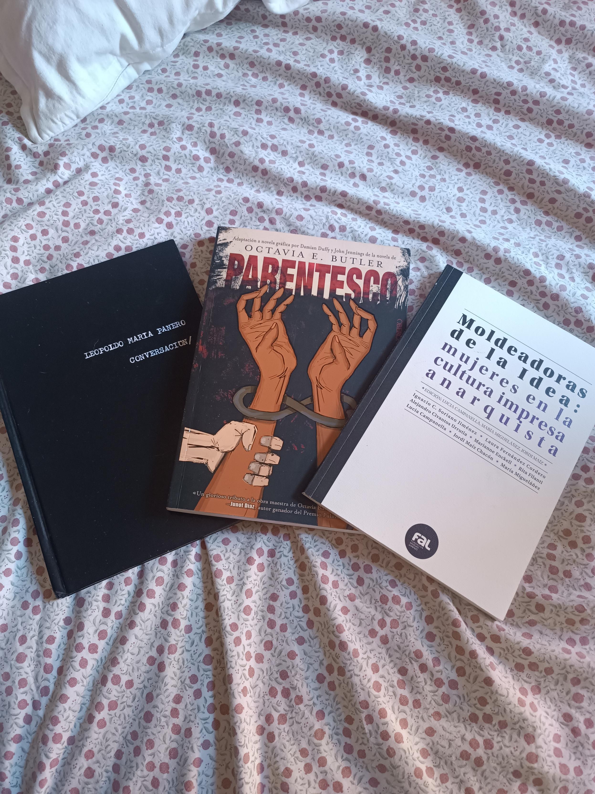 foto de tres libros: Conversación, de Leopoldo María Panero; la adaptación a novela gráfica de Parentesco, de Octavia E. Butler; Moldeadoras de la Idea: mujeres en la cultura Impresa anarquista, de FAL.