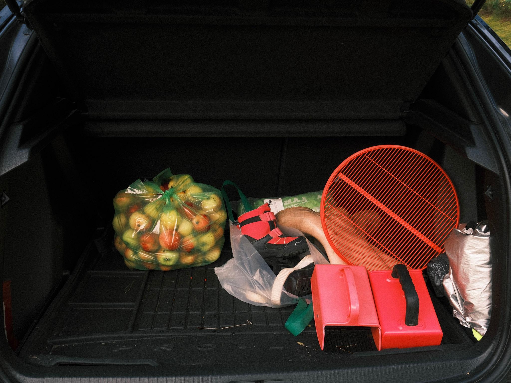 A car truck with a bag of apples, children's shoes, and Barry picking gear