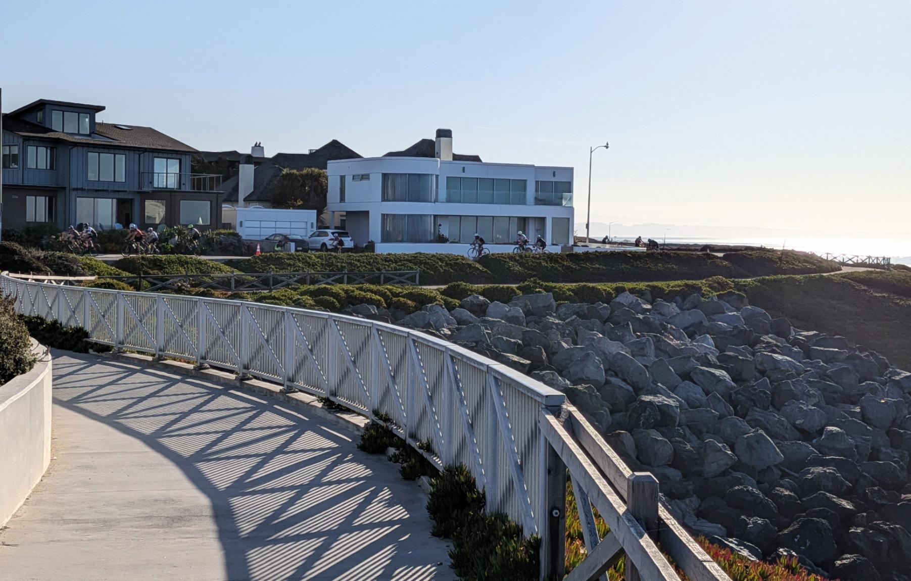 Path with hand rail, bikes on road near shore