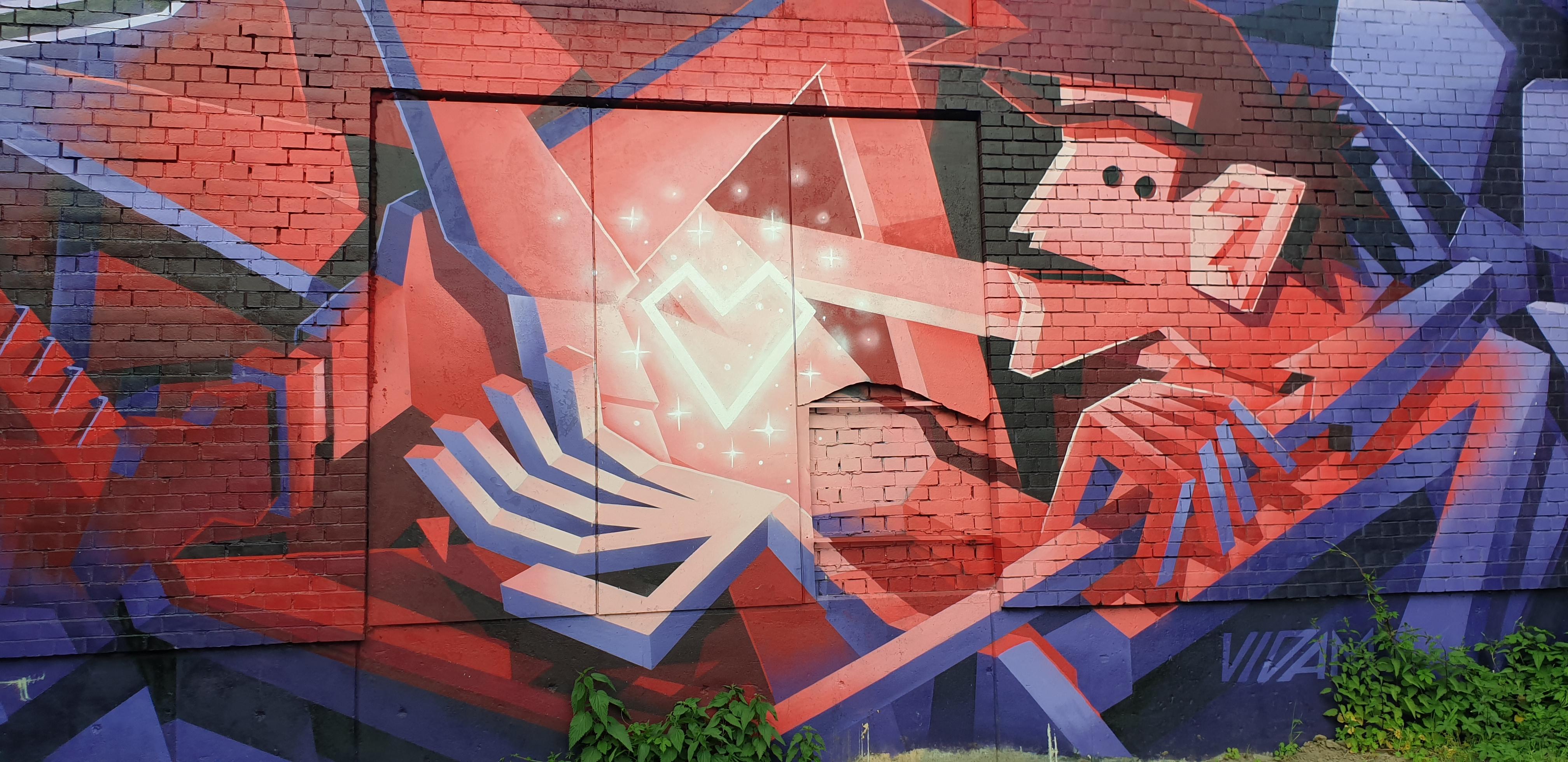 Graffiti auf einer Wand. Zeigt einen Mann im Comic-Stil über dessen Hand ein leuchtendes Herz schwebt.