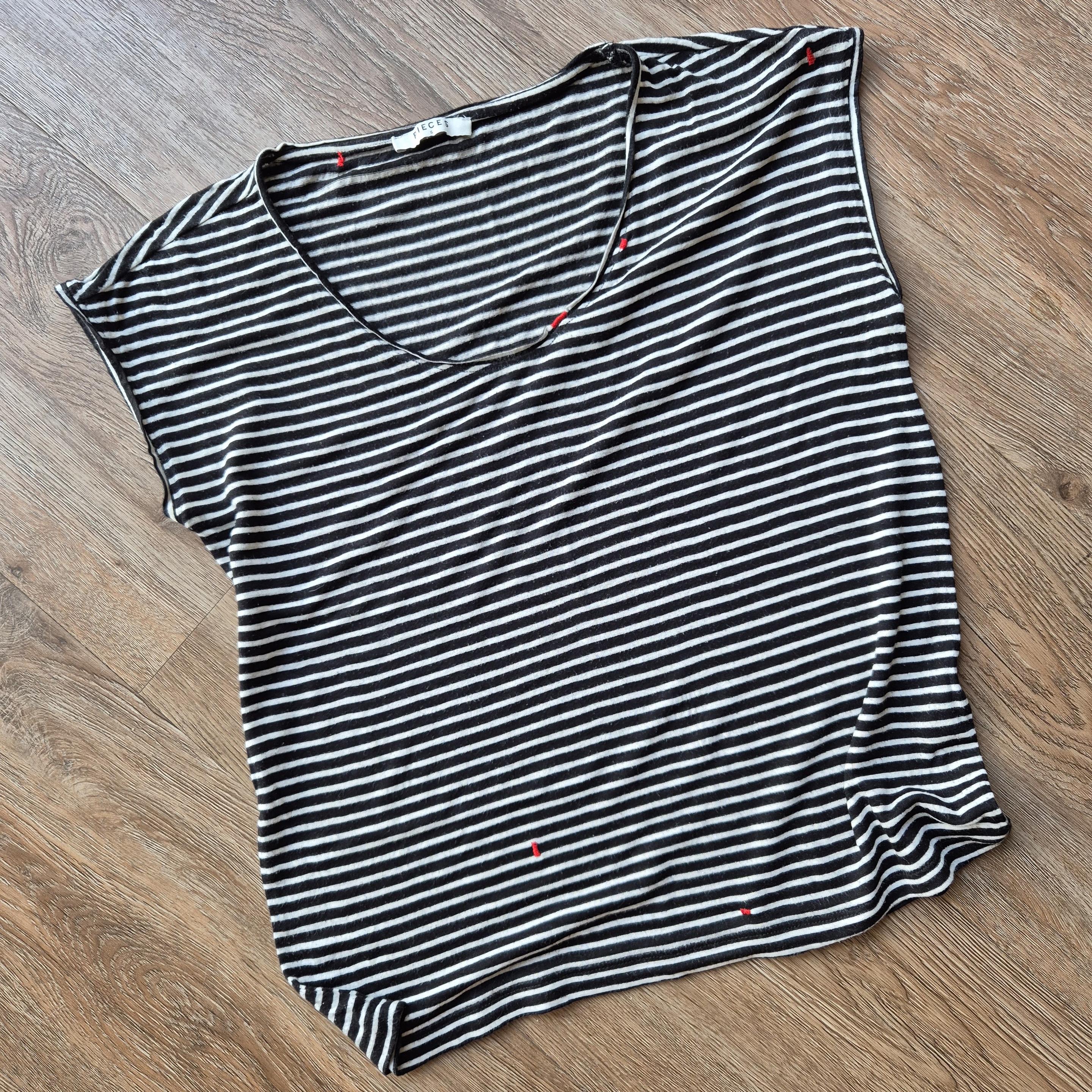 A black and white striped t-shirts with multiple mends in bright red. 