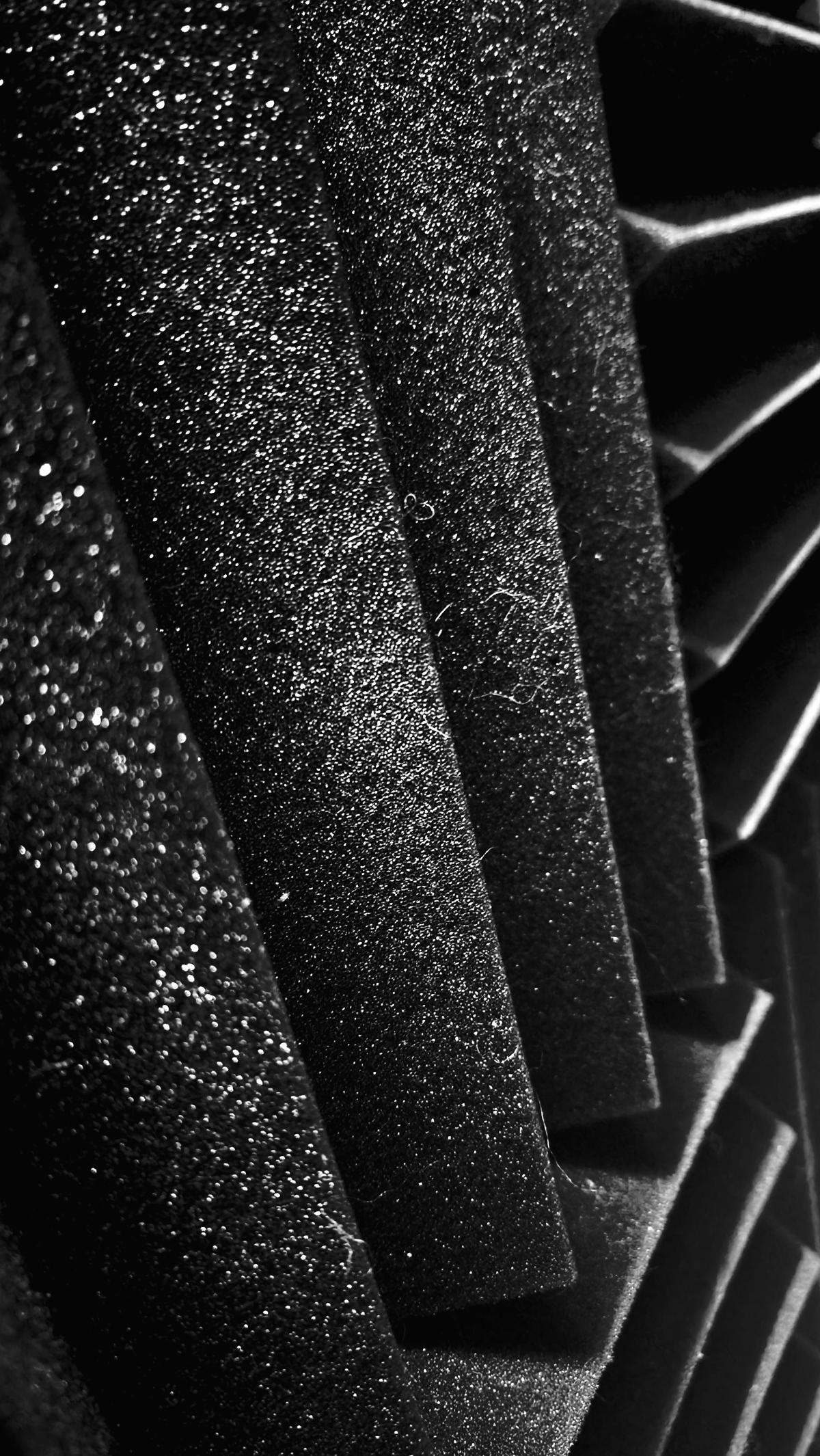 A black and white photo of a wall covered sound foam panels. The close up view lends the foams ridges a more brutalist architectural feel.