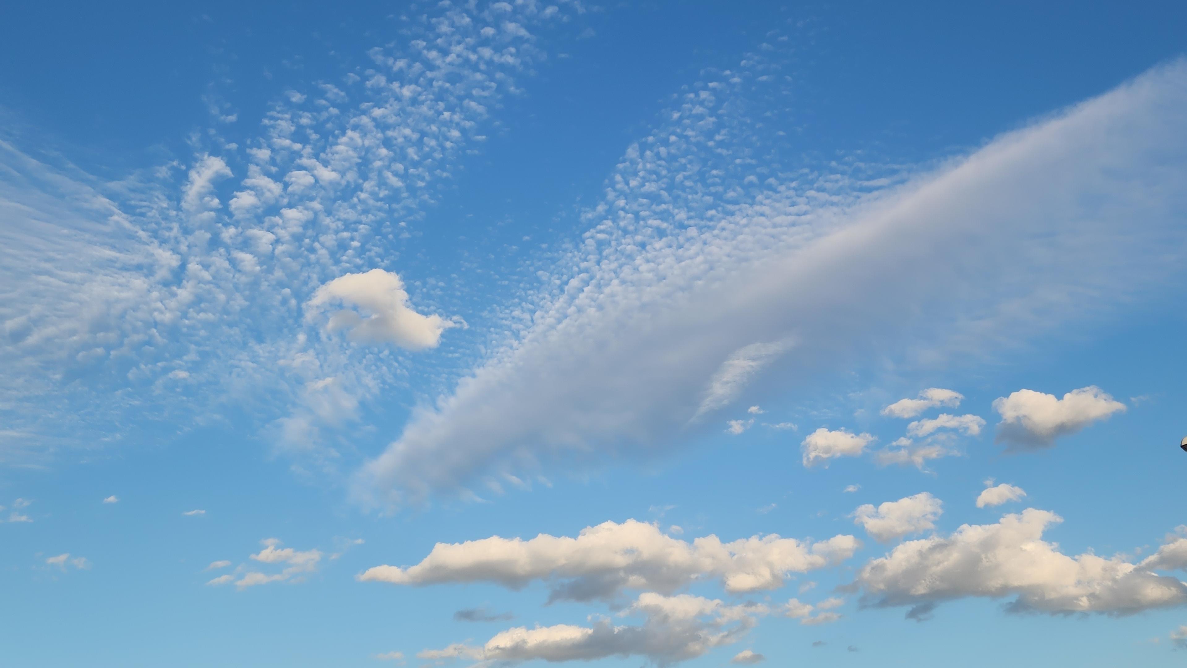 Blue sky with clouds of varying darkness and cloud type.