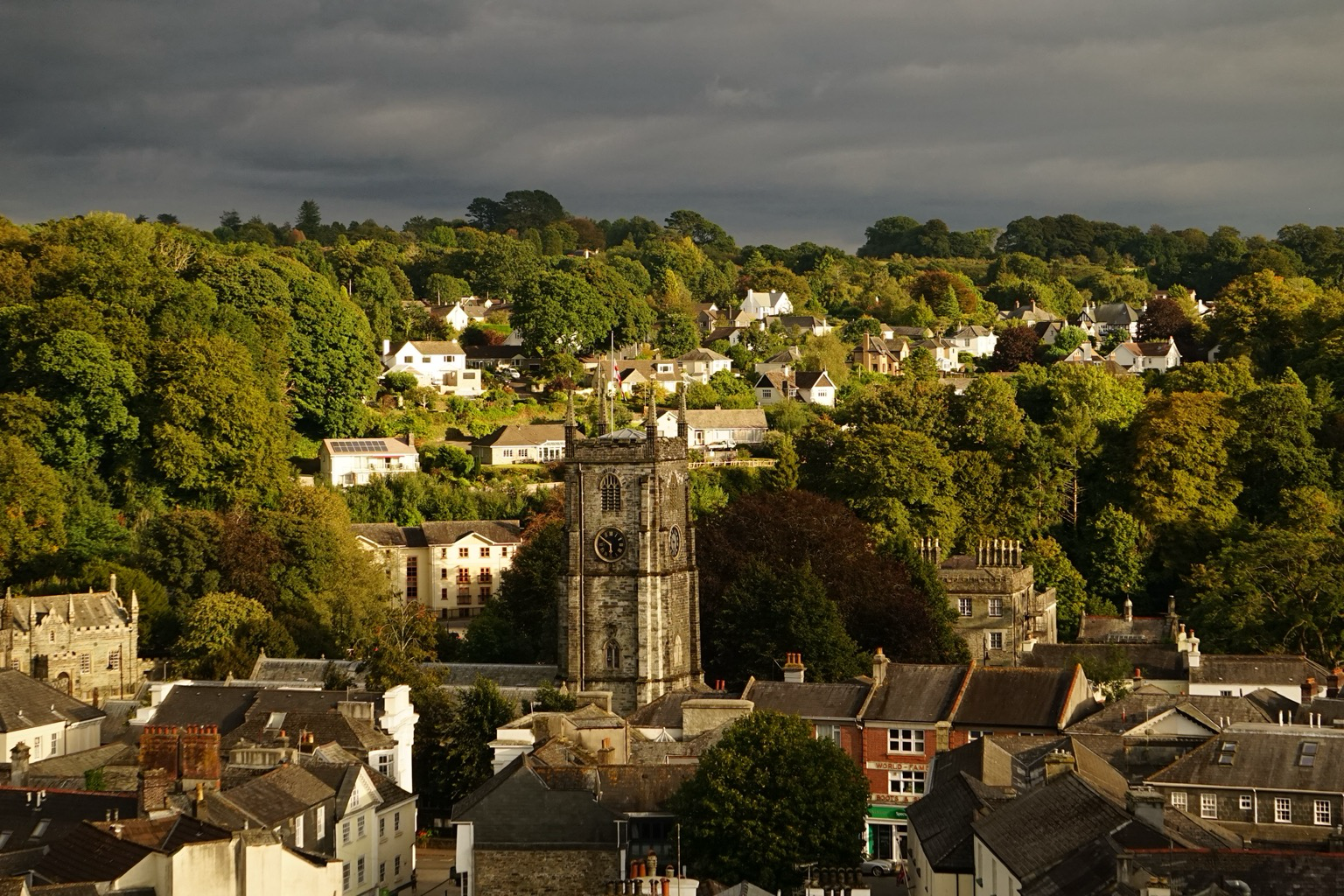 A medieval church stands under stormy skies in an English market town.