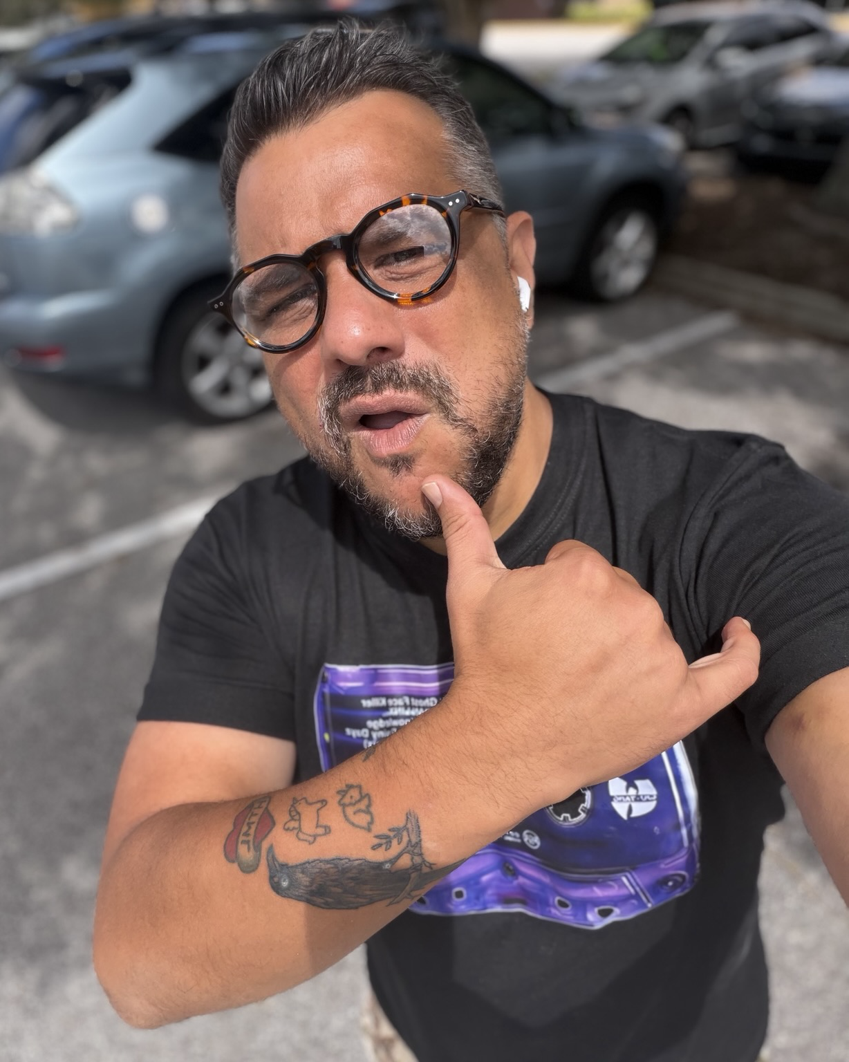 Me, a brownish man with turtle shell glasses and a black tee shirt doing this sigh 🤙