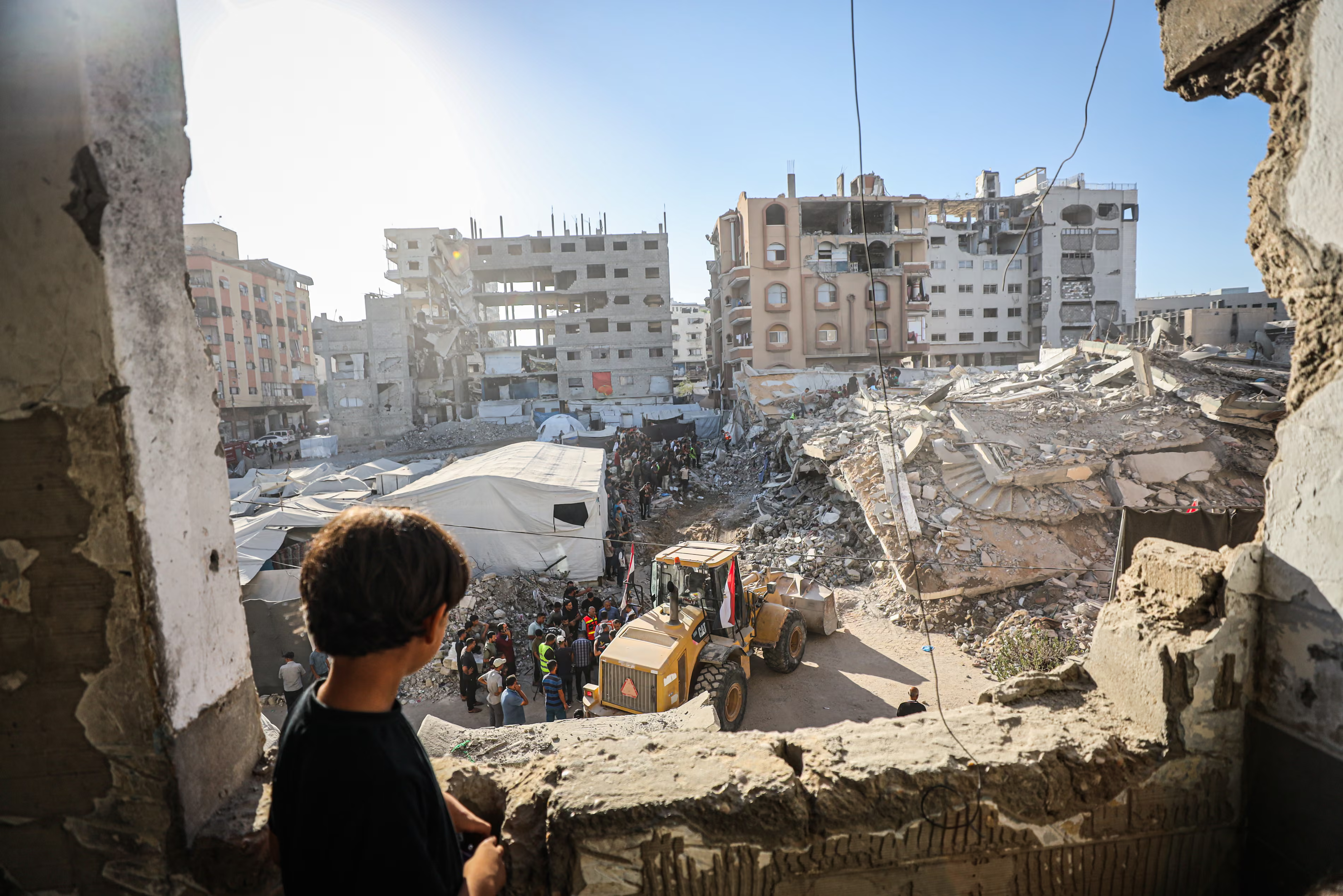 Rescue workers search for dozens of people trapped after a six-storey building housing about 100 displaced Palestinian people collapsed.