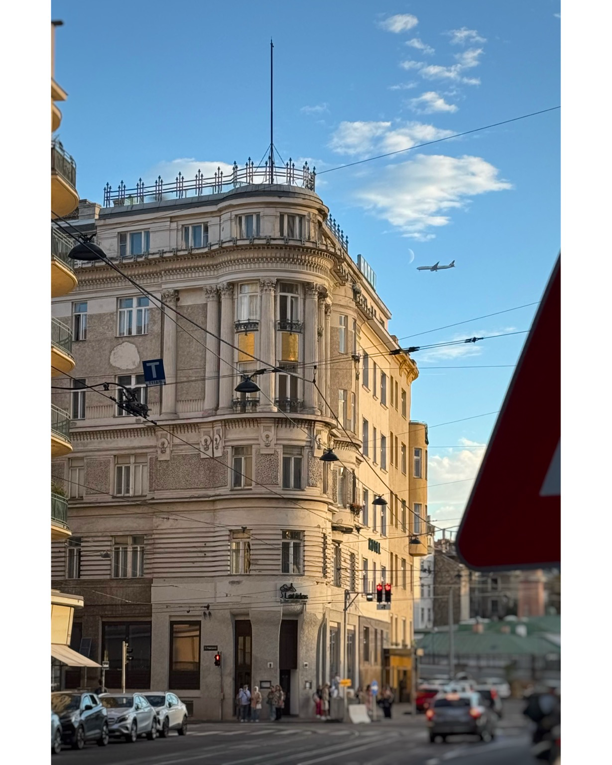 Sunset on building with half moon and airplane