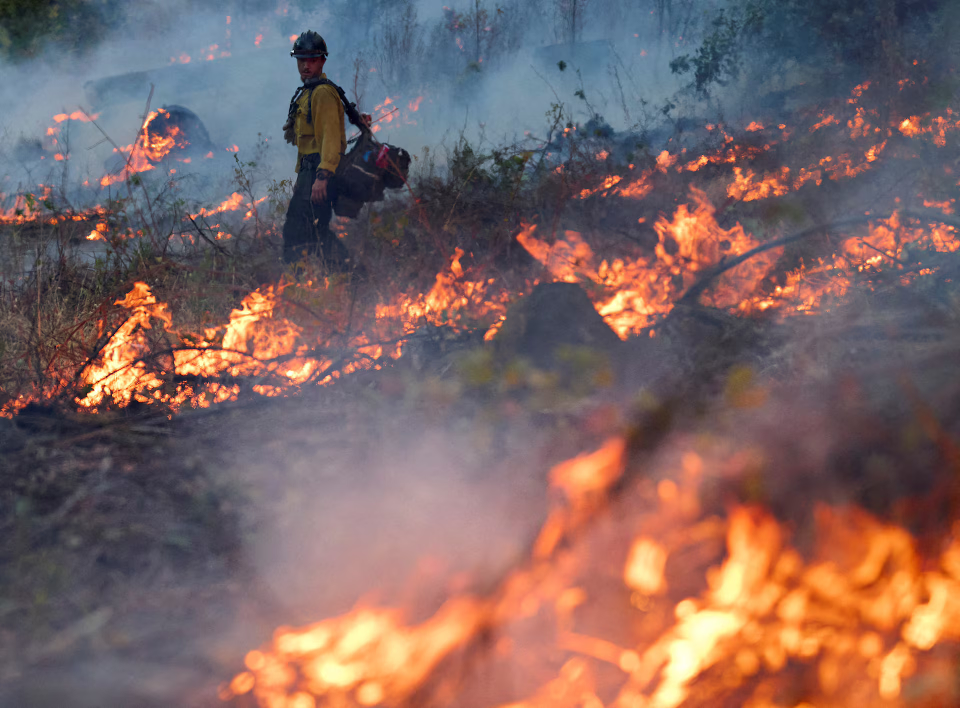 A firefighter monitors the progress of the fire.
