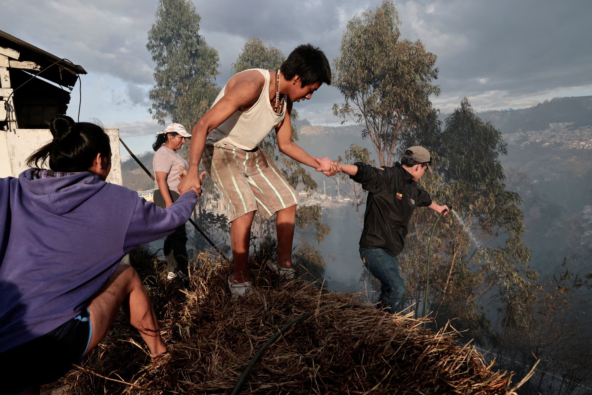 A family fighting a fire forms a human link on the side of a hill.