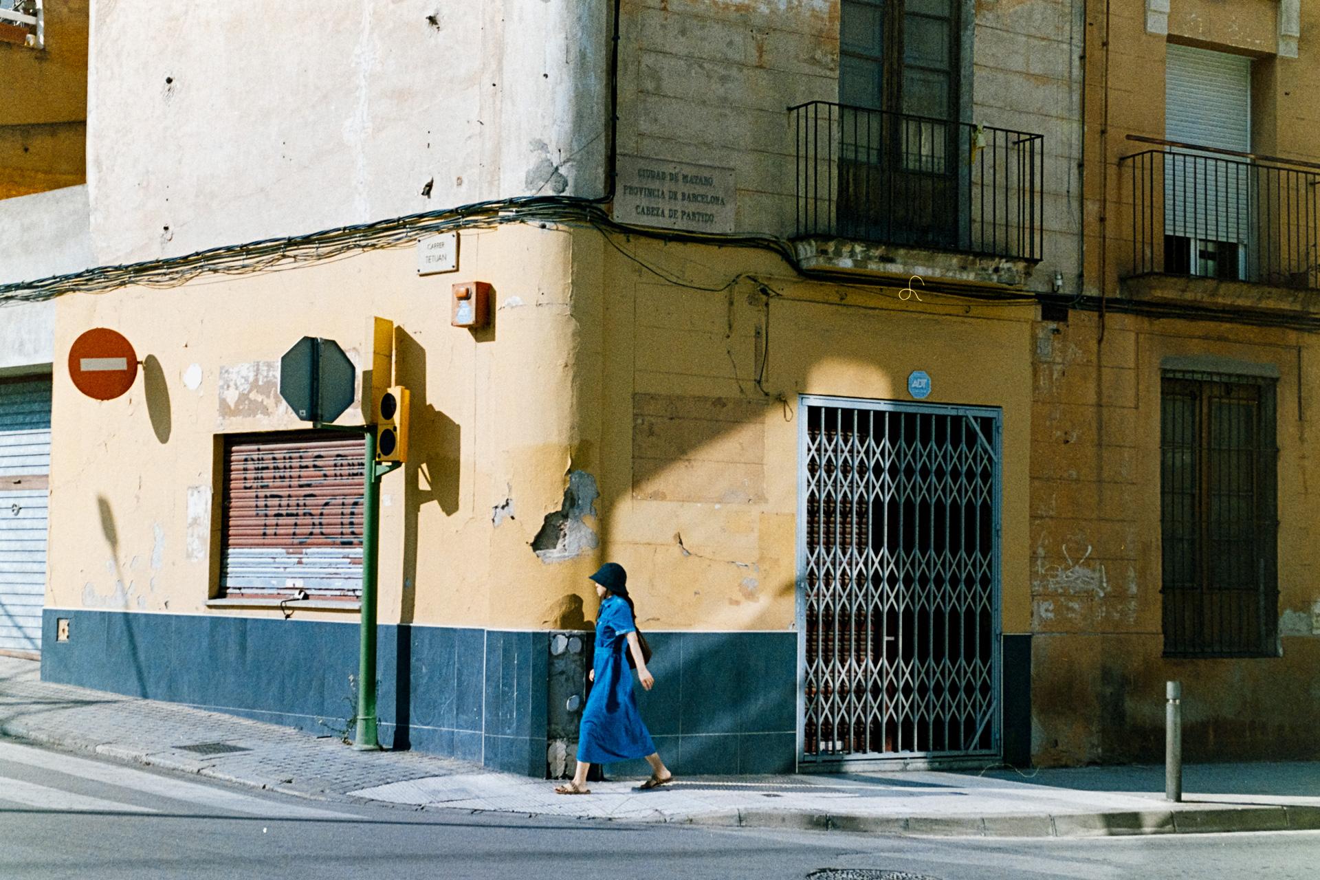 Fotografía de una persona paseando por una calle de Mataró al atardecer.