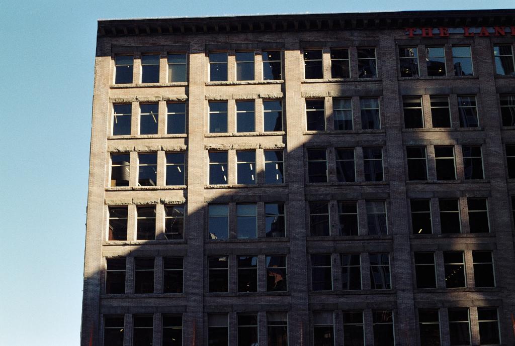 View of a portion of a 1905 brick building with many windows.