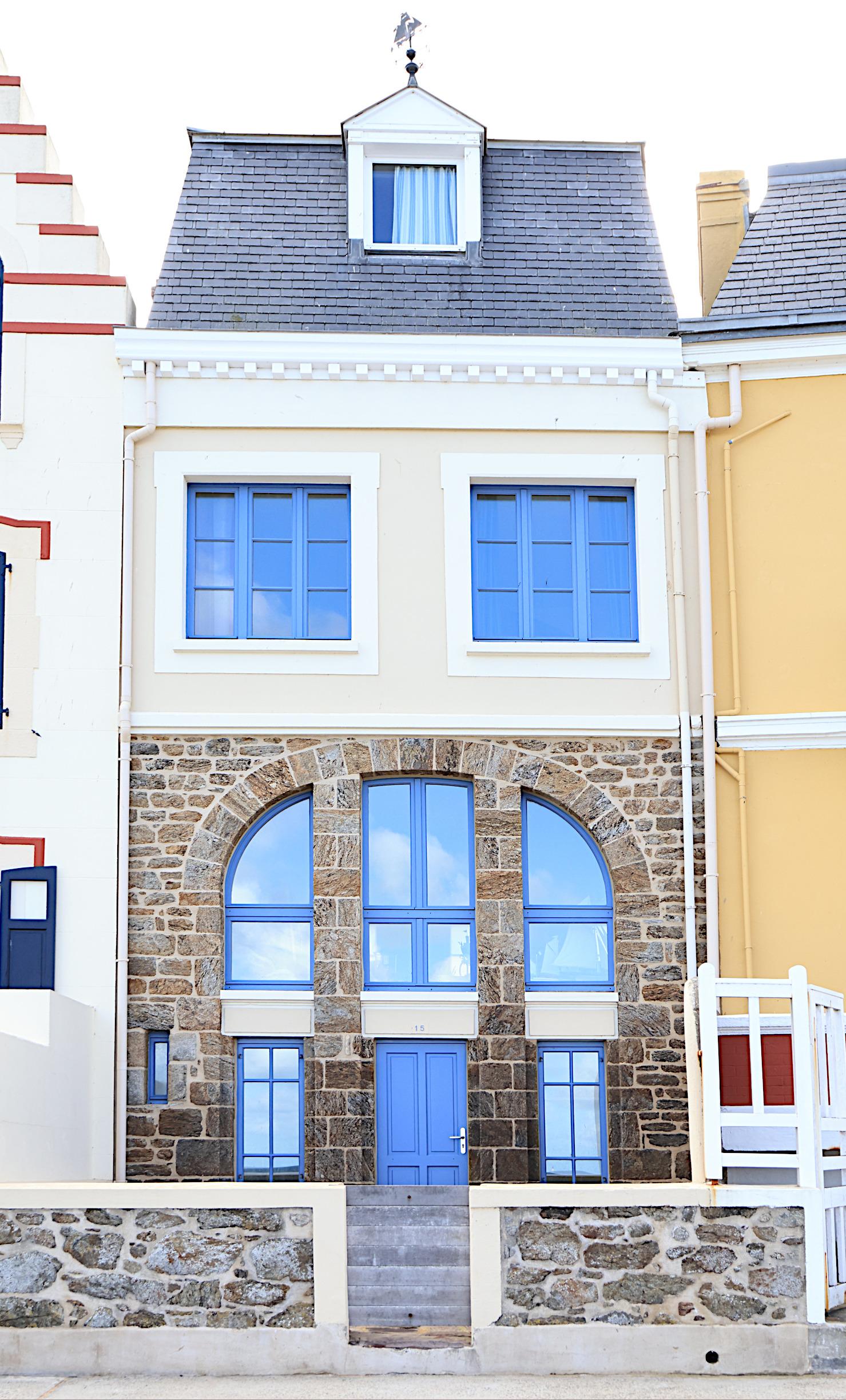 The window frames are interesting blue, the lower windows make an arched shape with the door.