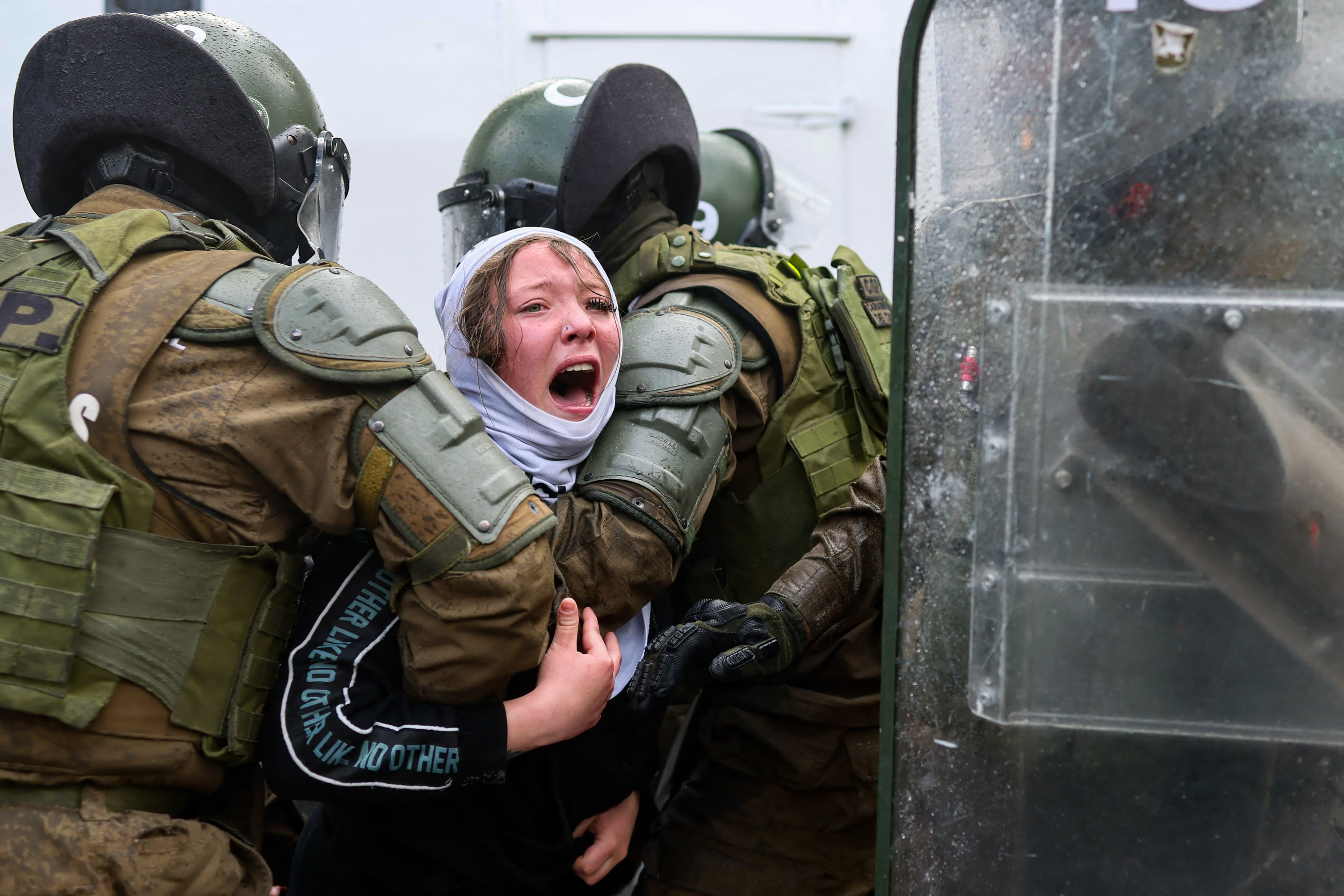 Carabineros detain a young woman.