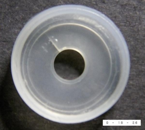 Opaque white plastic disperser/diffuser cap from a bottle of La Choy soy sauce (as seen from the side that snaps onto the glass bottle).  It measures 13/16ths of an inch in diameter.  (I've posted photos of more than 500 round things now and I think this is the first with that exact measurement.  Odd!)  The small hole in the center allows one to shake out small amounts of soy sauce.  Removing this cap allows one to pour out greater quantities of the sauce.  It's a rather ingenious way to keep one from accidentally drowning one's food in dark liquid.  I wish I had invented it!  But I wish even more that I could make one for my mouth that would prevent me from talking too much.  If I had to vigorously shake my head to get each noun and verb out I'd probably have more friends.  When it comes time to howl again at the moon, however, I could just remove my opaque white plastic mouth cap and let 'er rip.  *Leaving now to visit the US Patent Office website.*