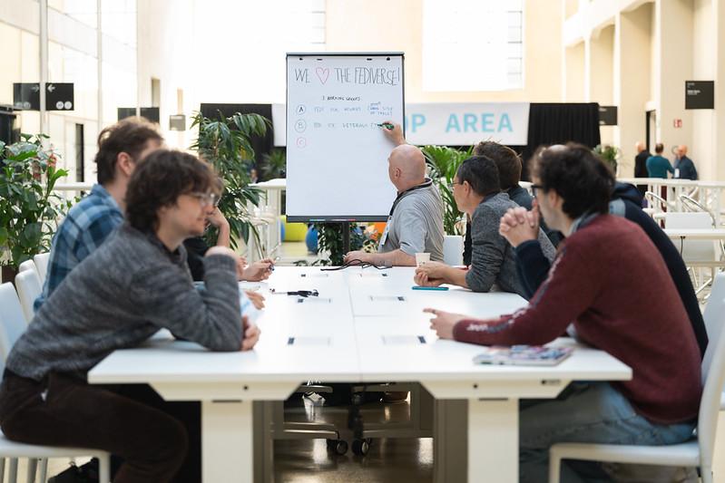 A group of people sitting and listening to a BOF session during SFSCON25.