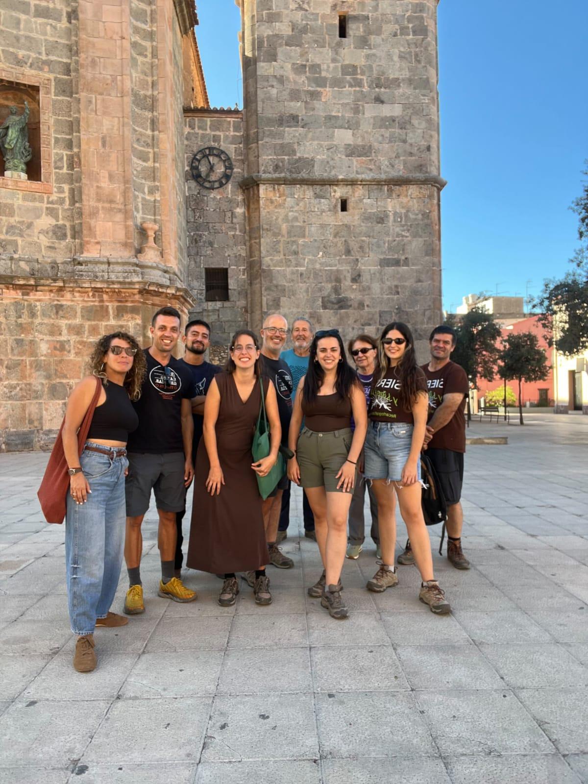 Grupo principal de recartografías donde aparecen 10 personas de distintos géneros, edades y nacionalidades. Detrás se ve parte de una iglesia.