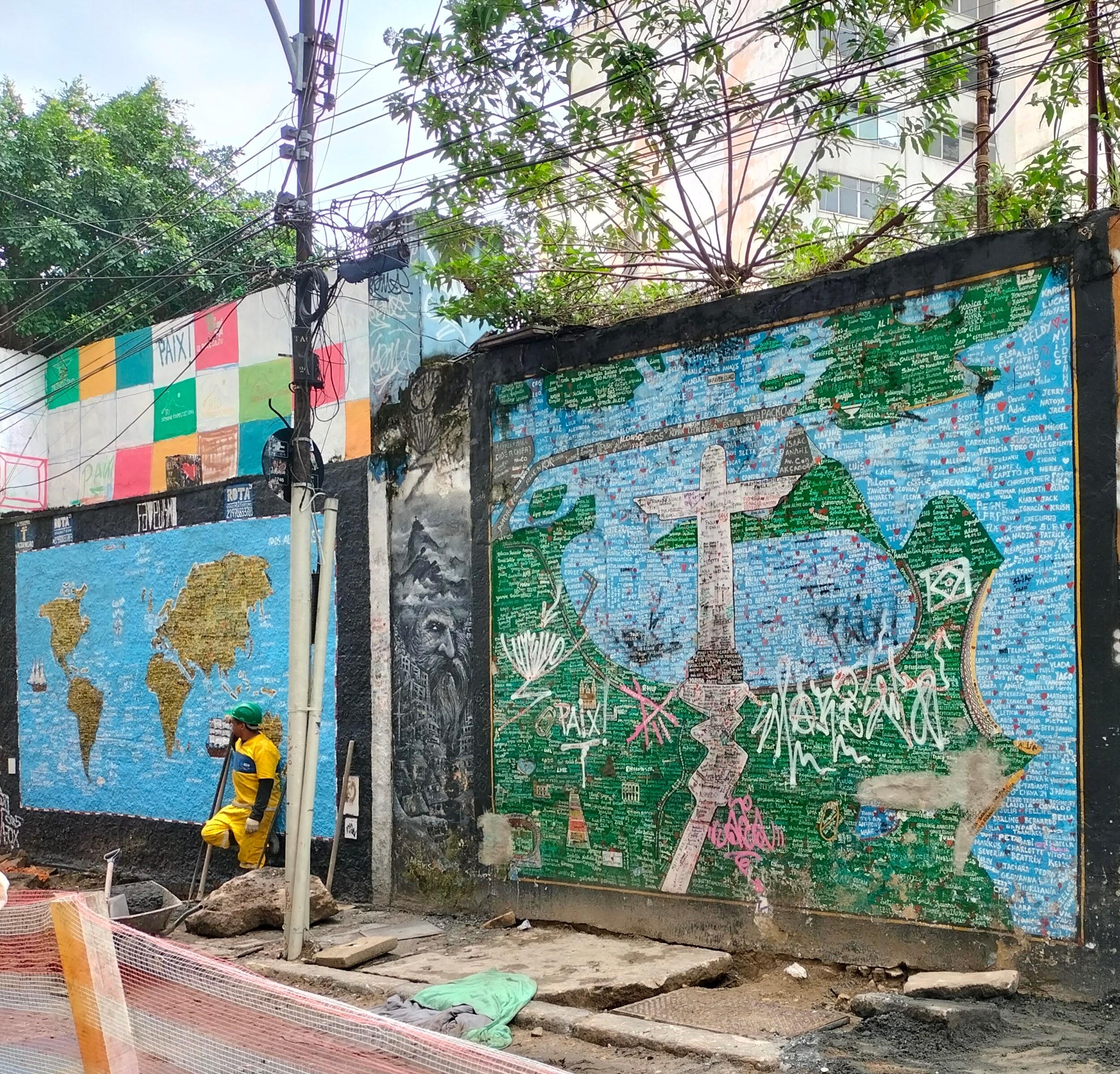 Camino escaleras de Selaron.Mapa de el mundo con obrero con mono amarillo y casco verde (colores de Brasil),blanco y negro hombre con barba larga y lo que creo es una ola encima,mapa de Río de Janeiro en verde y azul con Cristo sobre representado(parece un dibujo infantil) con muchas formas y algún tachón en blanco y rosa.