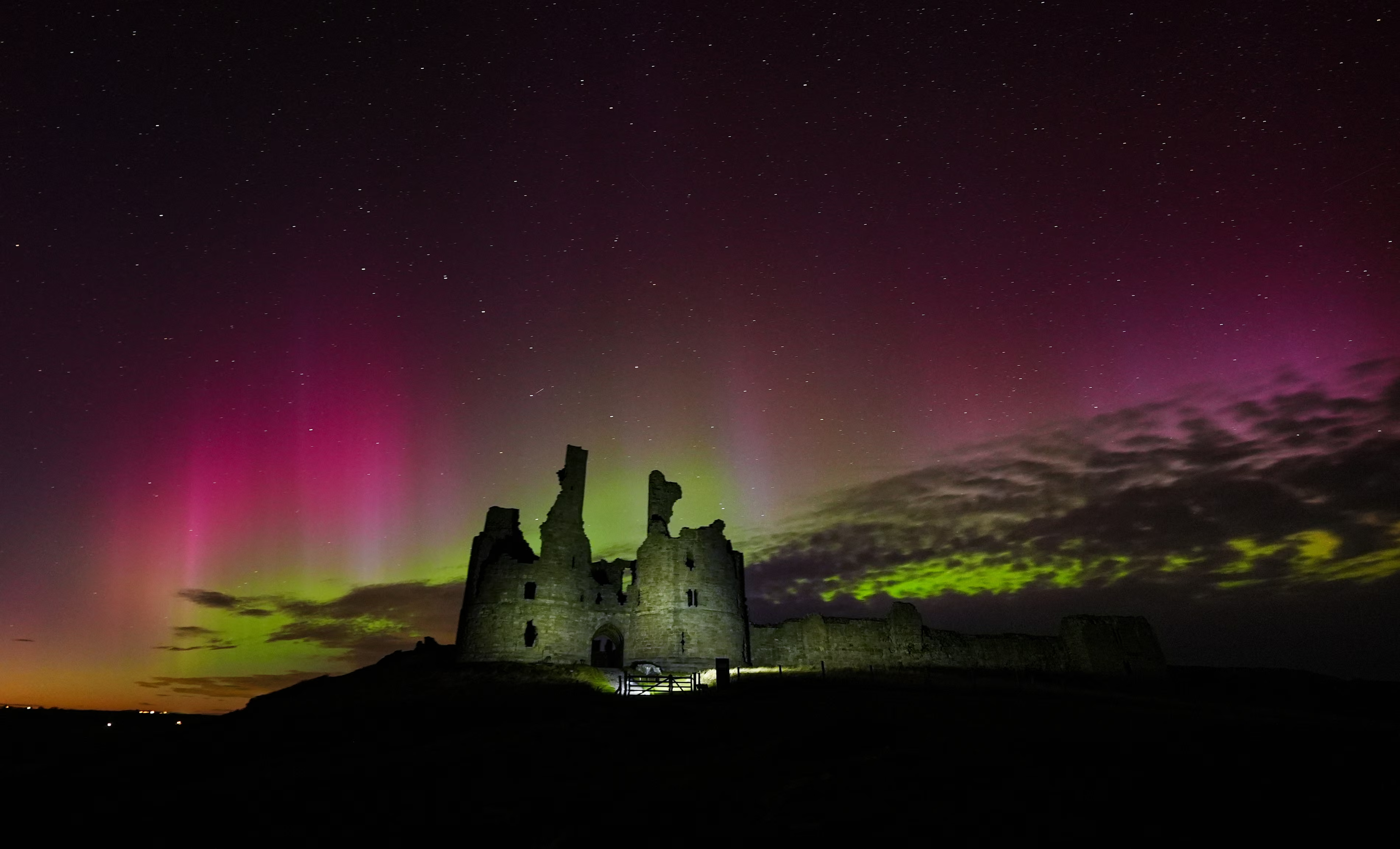 Aurora borealis  lights up the skies over the ruins of Dunstanburgh Castle on the Northumberland coastline.