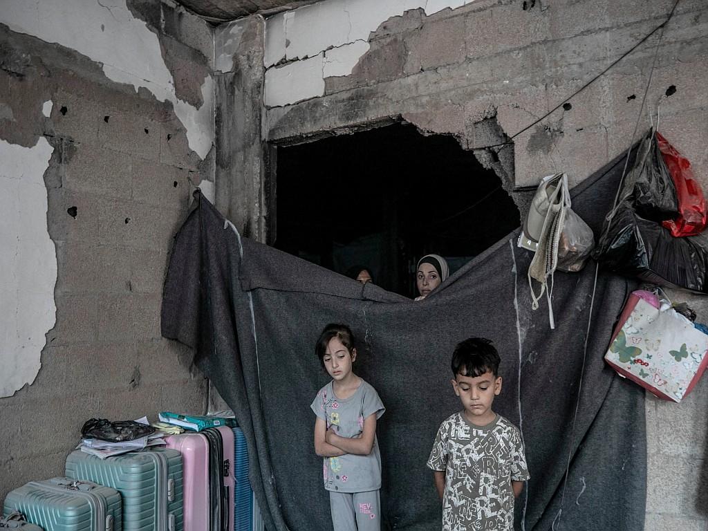 Palestinian family members look out from their destroyed home after an Israeli airstrike in western Gaza City.